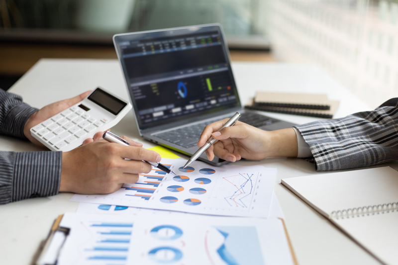 Meeting with business partners to discuss financial advisors to analyze market growth charts in business reports and plan investment strategies.